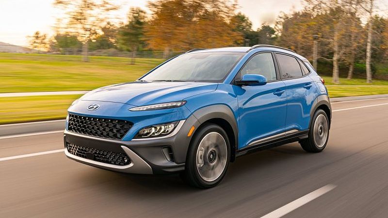 Blue 2023 Hyundai Kona Limited driving by a park