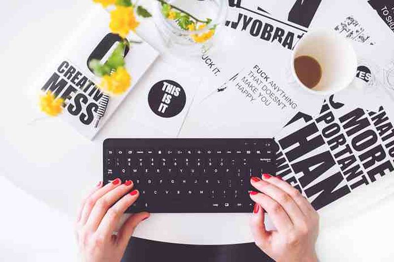 Girl typing on black keyboard