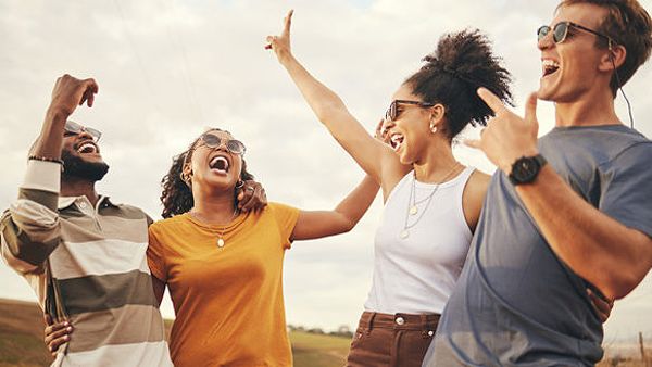 Group of joyful friends celebrating outdoors, representing Money Mentors' mission of achieving a debt-free lifestyle.